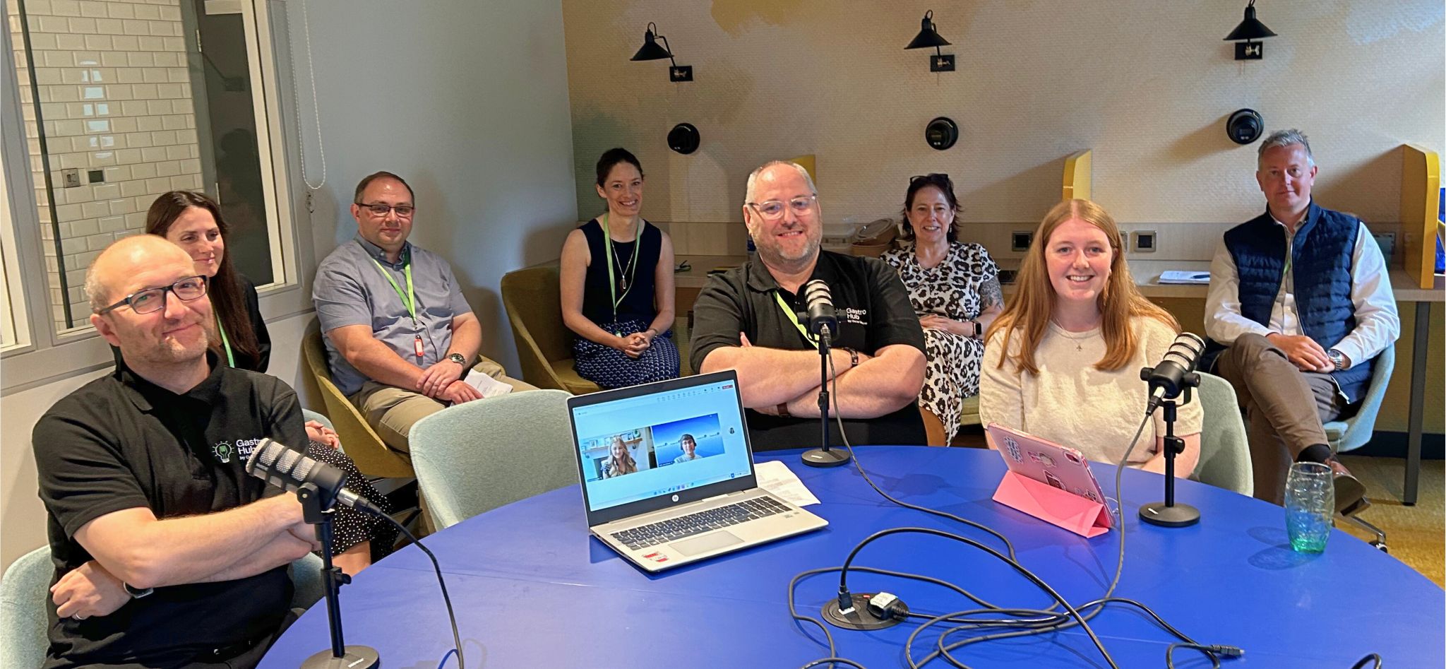 group of people around table recording podcast