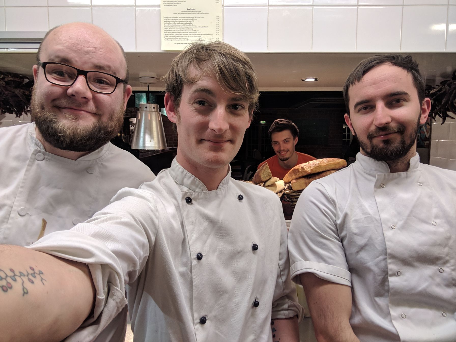three chefs in selfie in restaurant kitchen
